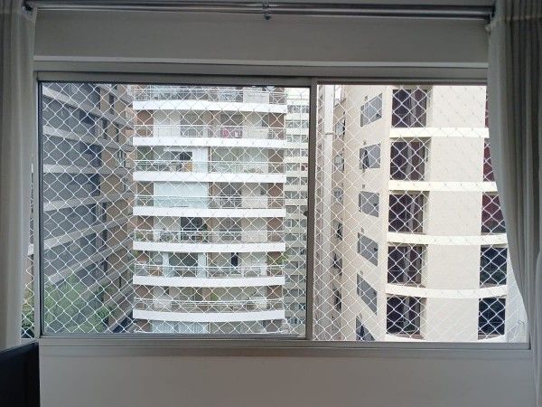Janela de apartamento com rede de proteção branca instalada