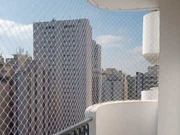 Sacada de apartamento com rede de proteção branca